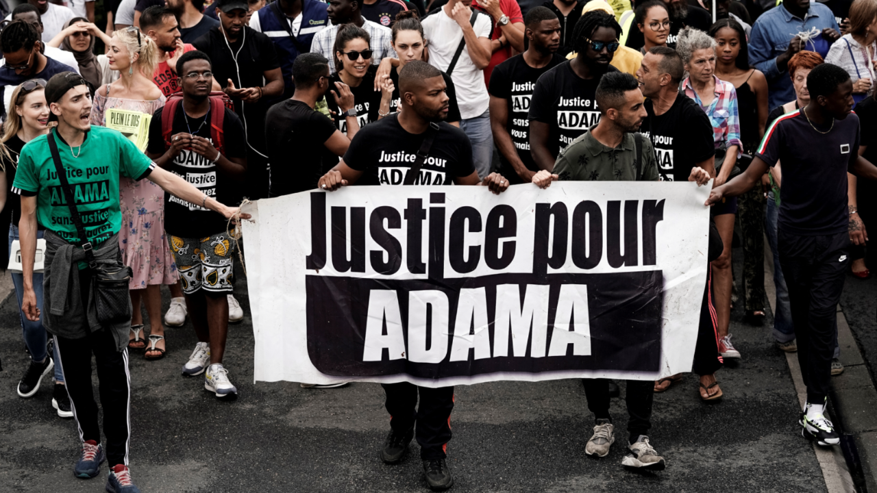 Manifestant tenant un portrait d’Adama Traoré lors d’une marche à Beaumont-sur-Oise